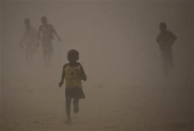 Refugees who fled the conflict in Sudan's western Darfur region run for shelter during a dust storm at Djabal camp near Gos Beida in eastern Chad June 19, 2008.

Photo: Finbarr O'Reilly/Reuters