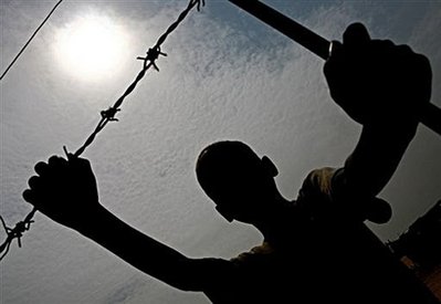 A Sudan boy holds onto the barb wire fence surrounding a water point in the Abu Shouq internally displaced people's (IDP) camp in the outskirts of el-Fasher, North Darfur, in 2007.

Sudan's government is still supporting genocide in Darfur, including through rape and holding up humanitarian aid, the International Criminal Court prosecutor said Wednesday December 3, 2008.

Photo: AMIS/Stuart Price