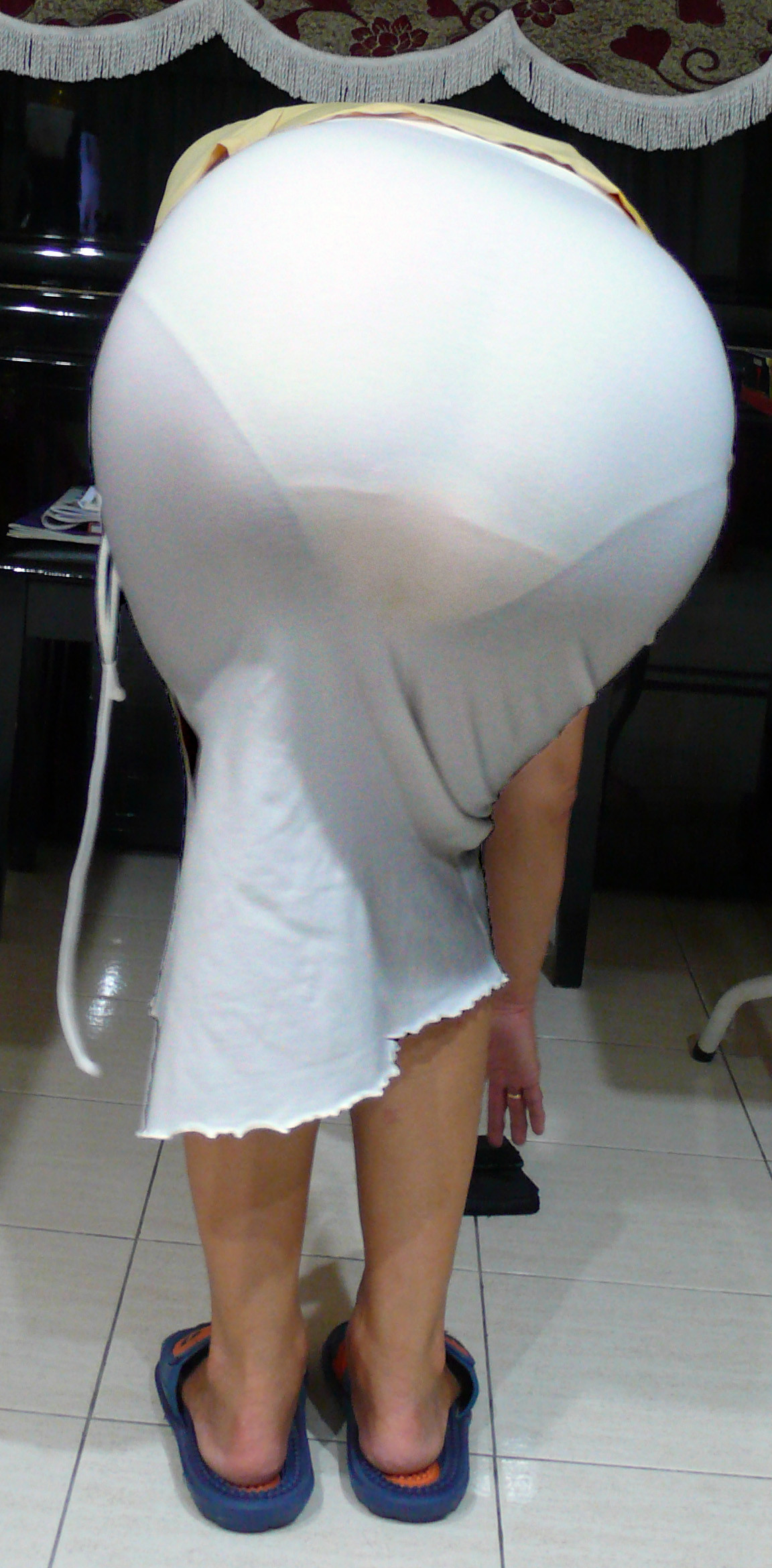 White skirt with clearly visible dark panties, bra cups, straps, clips and ...